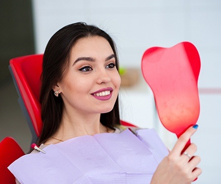 Woman looking at smile in mirror