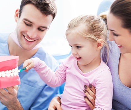Dentist and mother with young child in dental office