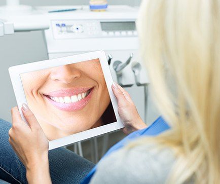 Woman looking at smile design on tablet computer