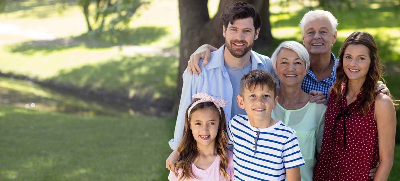 Three generations of family smiling outdoors