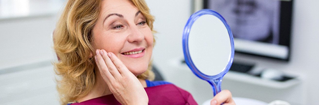 woman admiring her smile in mirror