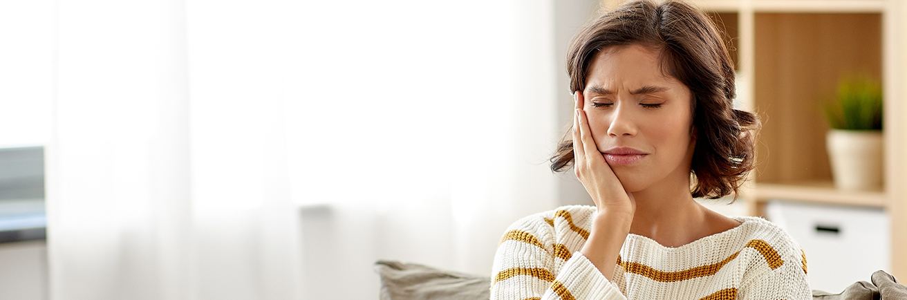 Woman in pain holding cheek