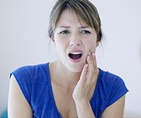 Woman in pain holding jaw