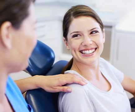 Woman in dental chair smiling at dentist