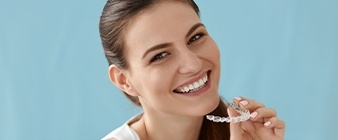 Woman placing Invisalign tray