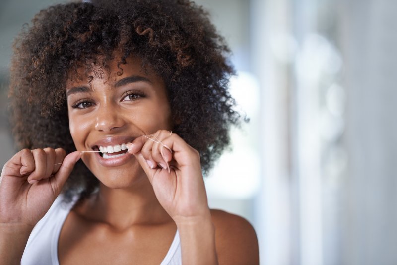 woman flossing for a dentist in Mt. Vernon