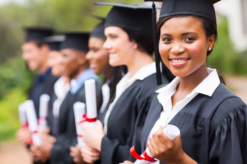 a graduate student smiling after undergoing cosmetic dentistry