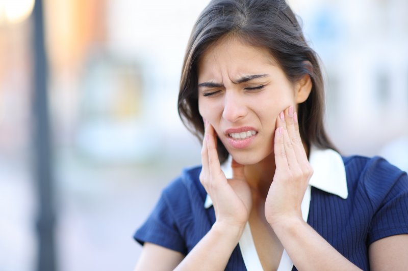 a woman experiencing a dental emergency during summer vacation