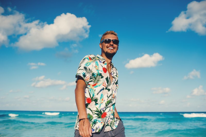 a man smiling during summer while undergoing Invisalign